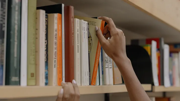 Main tirant un livre d'une étagère