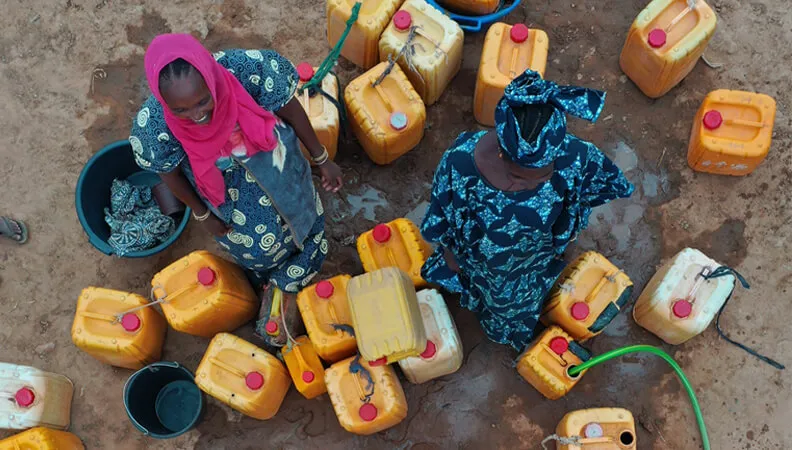 Femmes remplissant des bidons d'eau
