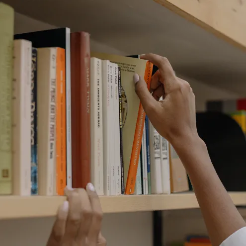 Main tirant un livre d'une étagère